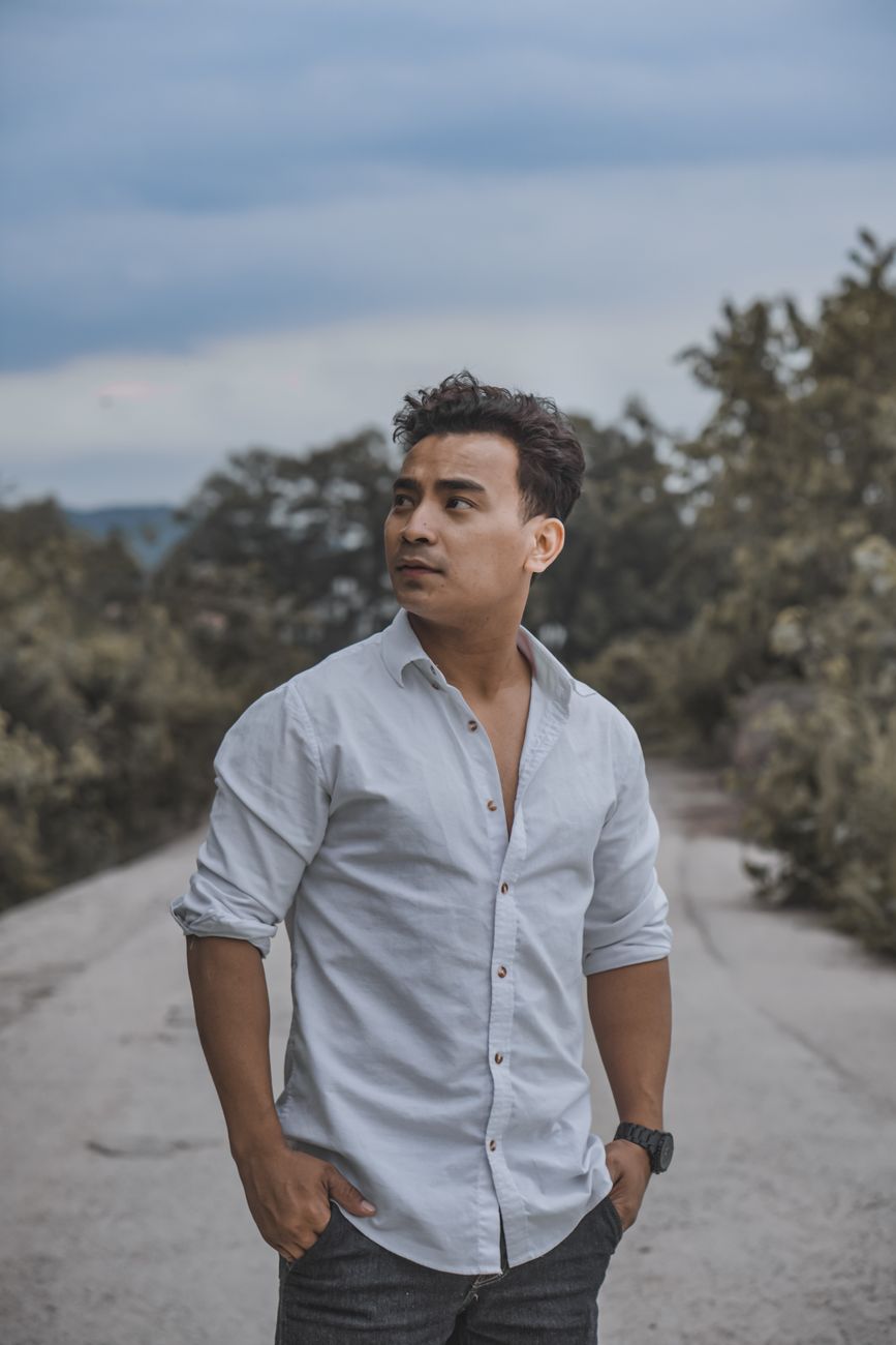 man in white button up shirt standing on road